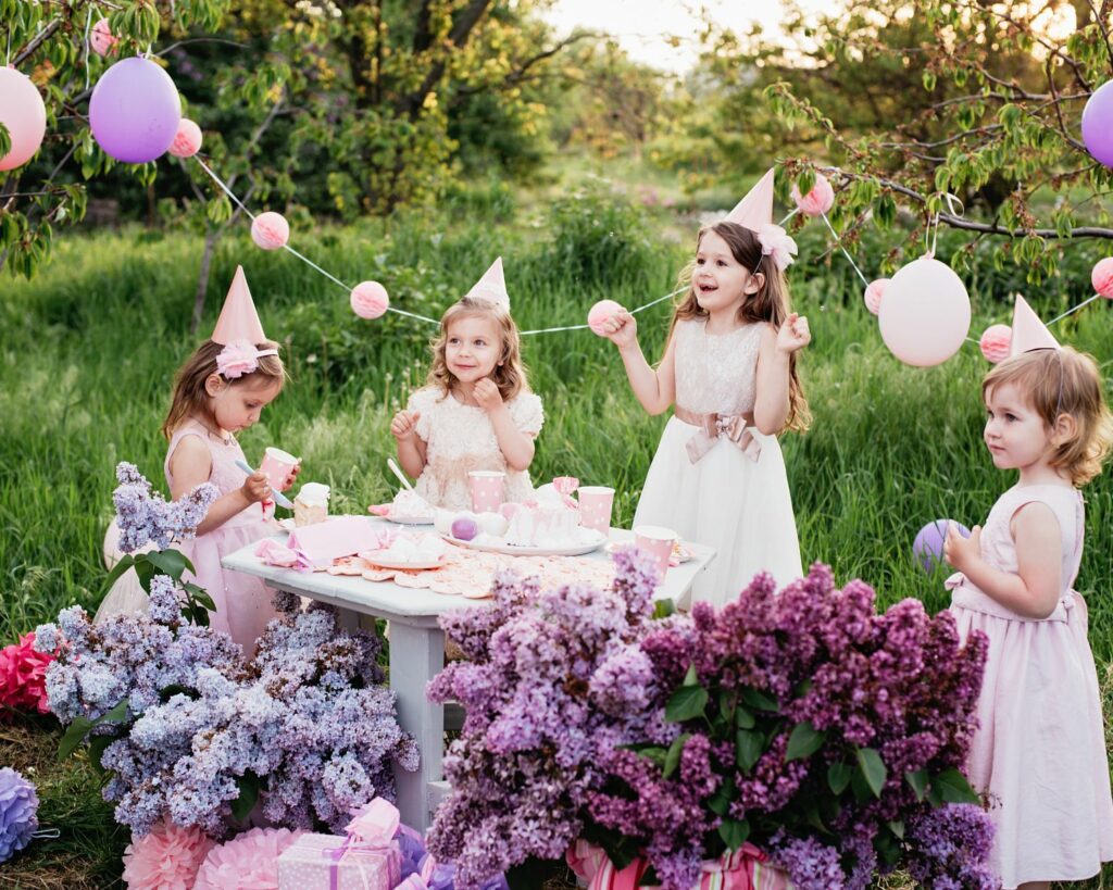 fête d'enfants dans un parc, avec des décorations roses et violettes