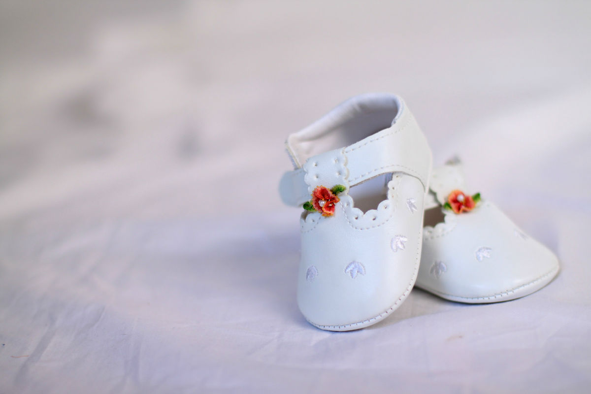 Chaussure blanche d'un enfant pour baptême