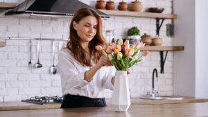 Femme arrangeant un bouquet de tulipe dans une cuisine minimaliste