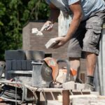 masonry worker the bricklayer makes the facade of the house from gray bricks