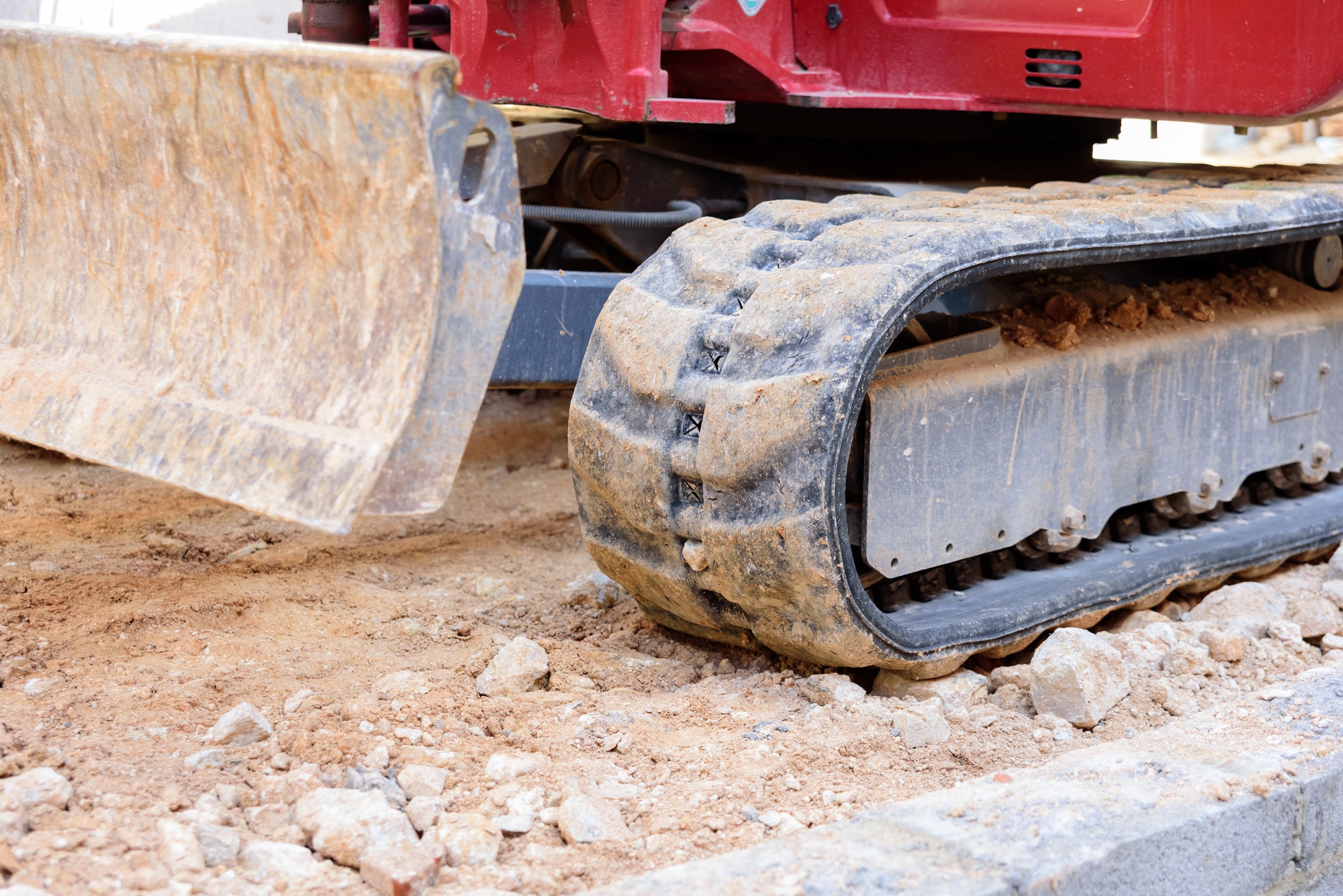 Caterpillar wheels of an excavator on rocks at a construction site.